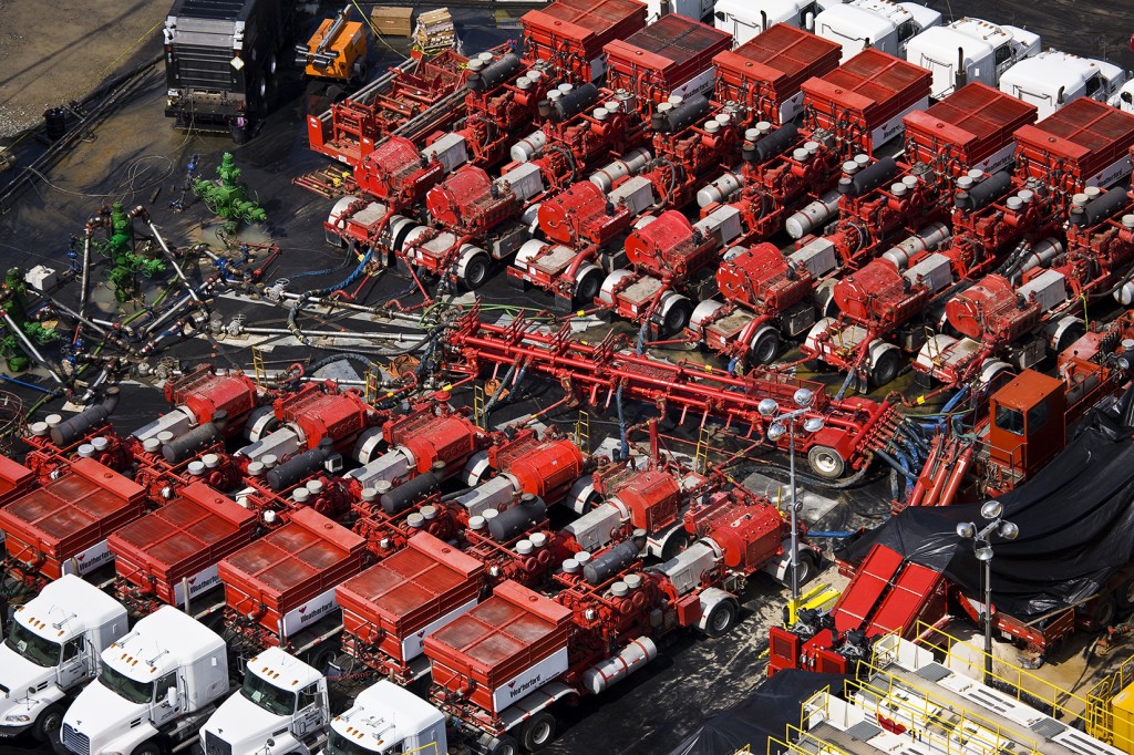 A fleet of Weatherford pump trucks attends to a hydraulic fracturing pad in...